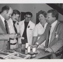 Five people looking at ACD memorabilia and photos
