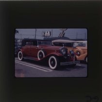Rolls-Royce and orange Packard in a parking lot
