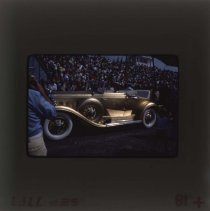 Golden Cadillac being shown to a large crowd at an auction