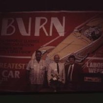 Gordon Buehrig and two men in front of a Auburn 83 banner