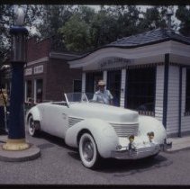 Cord 810-812 Cabriolet in front of a fueling station