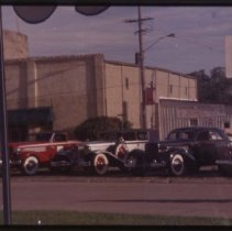 1934 Auburn, Cord 810-812 Sedan, Cord L-29 Phaeton, and a 1935 or 1936 Auburn Cabriolet seen through museum windows