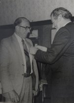 Andrew McLay accepting a badge from David Gamble