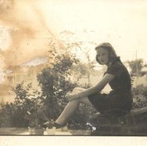 Young woman sitting on a wall