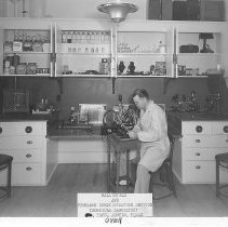 Gonzaullas at microscope at Ballistics and Firearms lab, TDPS