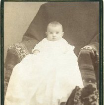 Sepia-tone photograph of Ralph Elmer Shattuck wearing white christening gown
