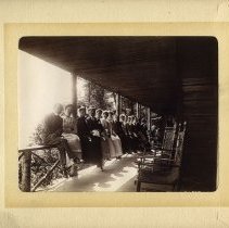 E. Alice Austen, [Large group sitting on a porch railing], 1899