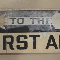 Sign, "To The First Aid"