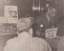 An unidentified man is waited on by Orville Jackson . . . during the 1940s