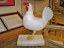 a wooden carving of a chicken