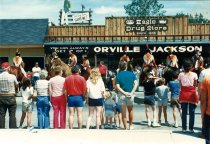 Crowd watches a group dressed as Native Americans on horses on State St