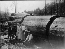 Large log, Oppenlander Ranch, with Group Posed in Front.