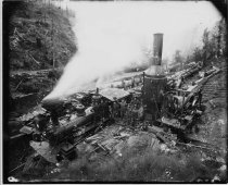 Steam train being loaded by donkey engine