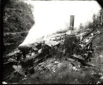 Steam train being loaded by donkey engine