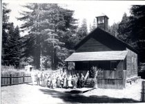 MCHS group poses in front of schoolhouse at Camp 20 of Caspar Woods.