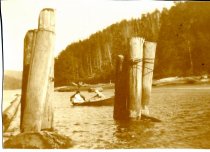 Two women in rowboat framed by pilings from old mill site, Big River.