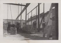 Black and white photograph of Kress construction site with frame being inst