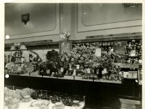 Black and white photograph depicting the interior flowers sales area, taken