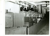 Black and white photograph of interior piping and heating burners, received