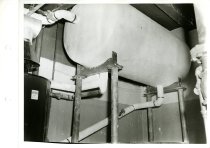 Black and white photograph of interior water heater machinery, received on