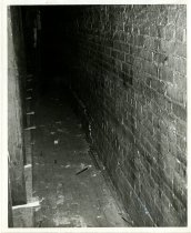 Black and white photograph depicting fire damage of brick wall (likely alle