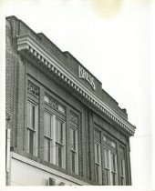 Black and white photograph depicting detail of exterior front logo, taken i
