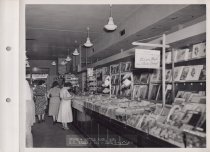 Black and white photograph of sales floor and shoppers