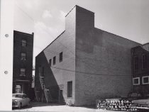 Black and white photograph of Kress back alley with parking visible