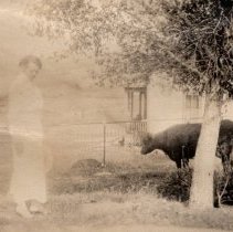 Woman near an old ranch house.