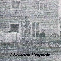 Primus Carlson standing on wagon in front of saloon in Bernice.