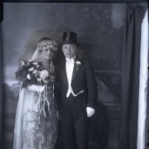 Image of a bride and groom on their wedding day posing. Bride is holding bo