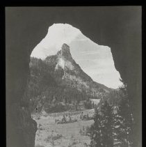 Image is a little faded. View is looking through a cave, maybe, looking tow