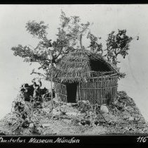 Image of a hut with a man outside. This image maybe a display but could be