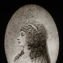 Portrait of a profile of a woman with curly hair. Image is an oval.