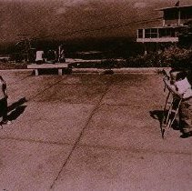 The People of America (man on crutches taking photo of woman)