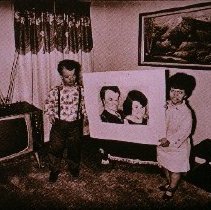 The People of America (man and woman holding large portrait of themselves)