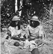 Two Paiutes working with hide or other material