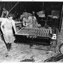 Thelma Linquist and two men preparing ingot mold  -  BMI Series