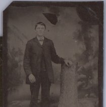Tin type photo of a man with hand on stump.