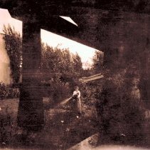 Fannie watering behind garage