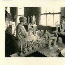 Cowan employee Mona Townley trimming a greenware piece.