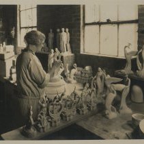 Cowan employee Mona Townley trimming a greenware piece.