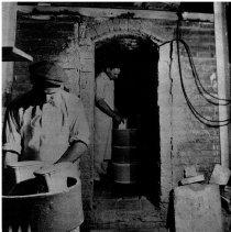 Kilns, George Brunt (foreground) and William Withroe (background) loading the kiln with bisqueware.