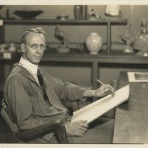 Reginald Guy Cowan in his studio posed with a pencil and paper