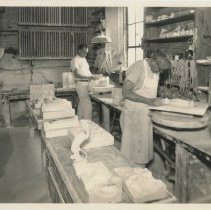 Two Cowan Employees, Jack Waugh (Foreground), releasing objects from plaster molds.
