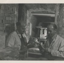 Two people unloading a kiln