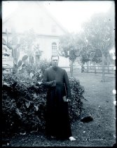 Father Andre Burgerman, SS.CC., with Our Lady of Victory Church in the distance, Lahaina, Maui.