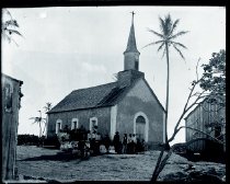 Priest and group of people in front of church in Puna built by Father Damien De Veuster, SS.CC.