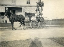 Two Unknown Women in a Buggy Outside of a House