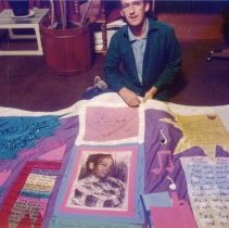 Man poses with quilt